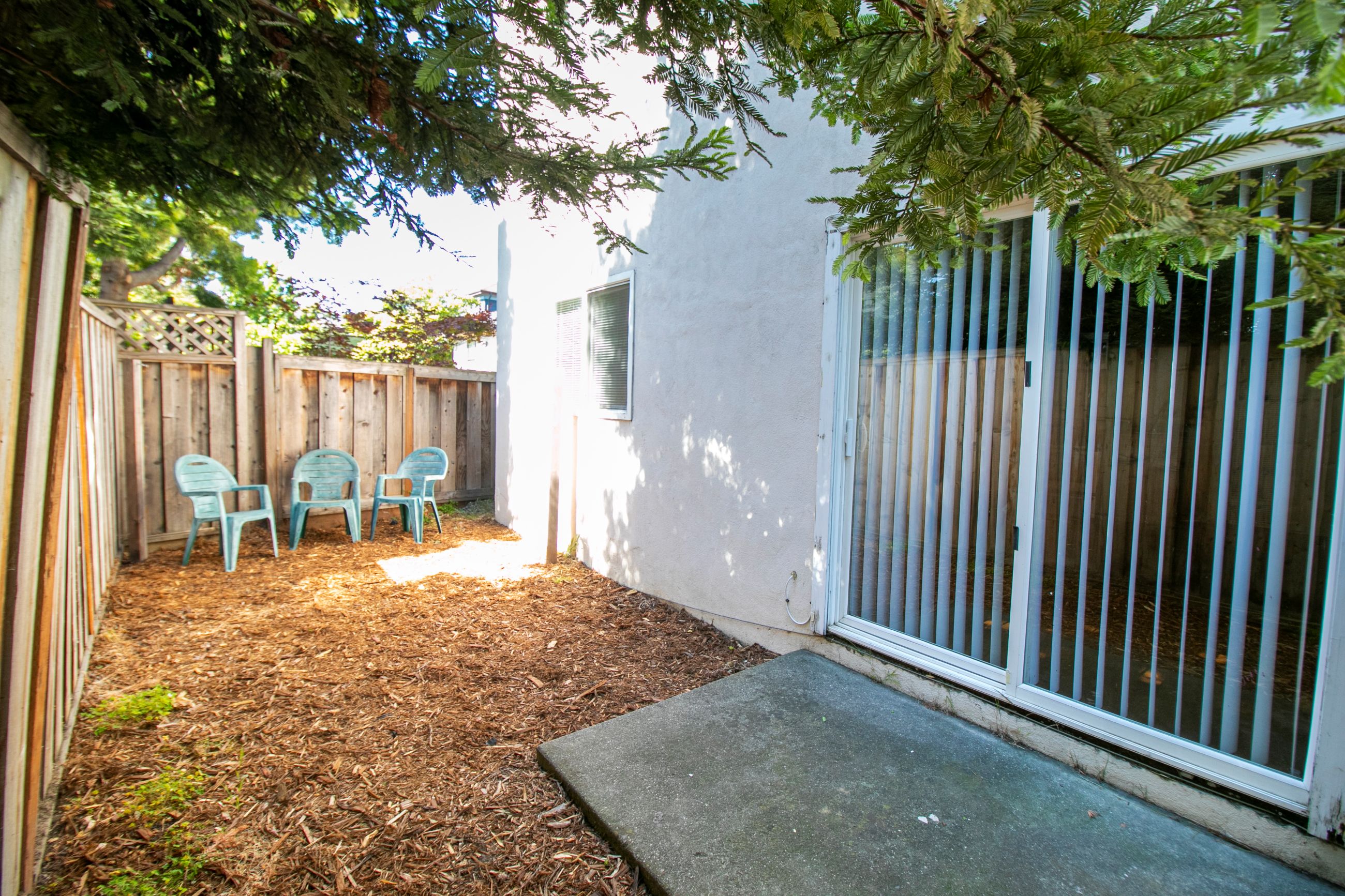 A patio with a white wall and a white fence.